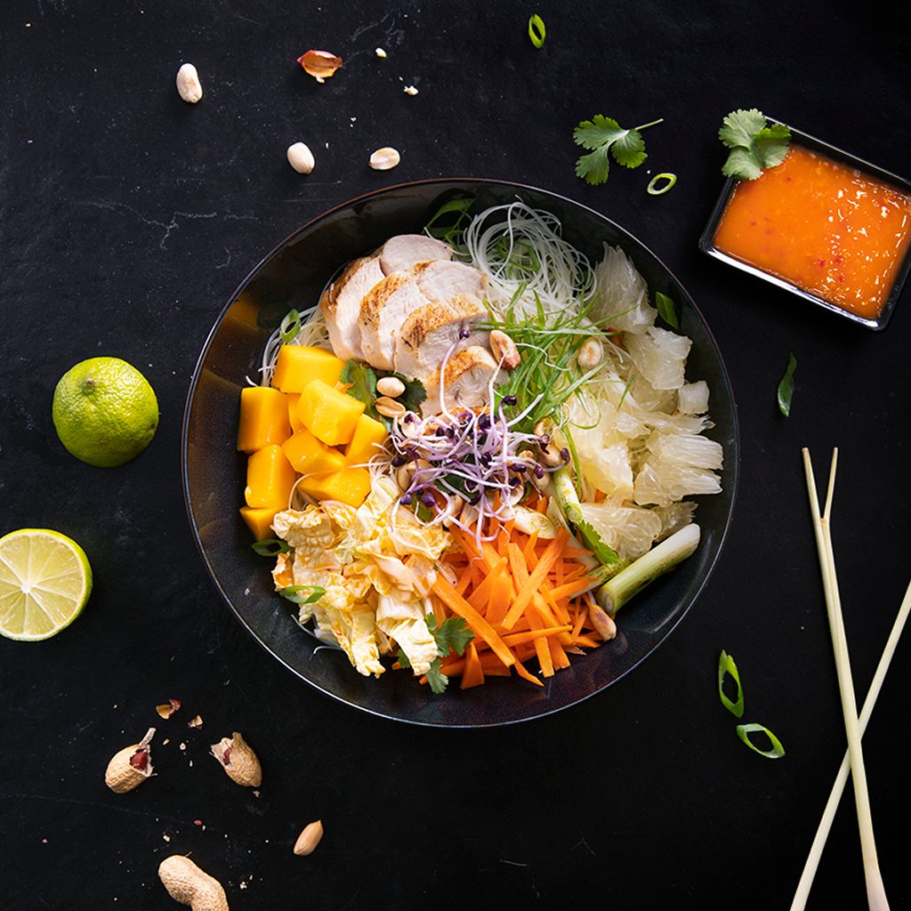 Frisch angerichtete Thai Bowl Creation mit knackigem Gemüse, Reis, frischen Toppings und asiatisch inspirierter Sauce in einer Buddha Bowl serviert.